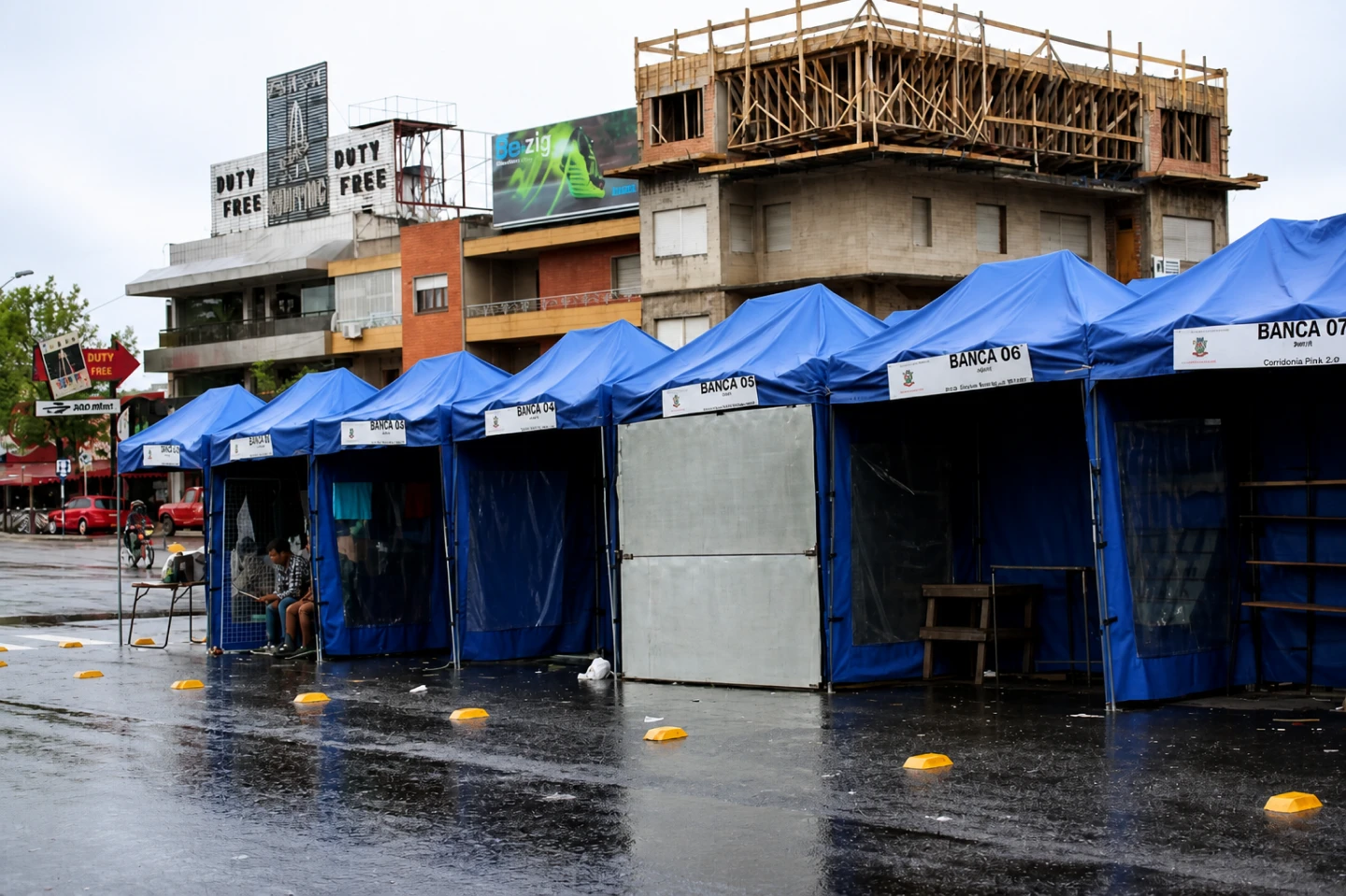Bancas cobertas por tendas azuis em evento de rua